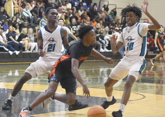 Olympia's Kevins Charles (21) and Kaiden White (10) pressure Leesburg's Evan James during the second half Thursday at Olympia High. White scored a team-high 19 points to lead Olympia to a 65-55 victory. Charles added 12 points and five rebounds.